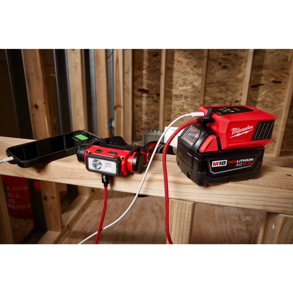 Milwaukee M18 TOP-OFF powering a phone and headlamp on a jobsite