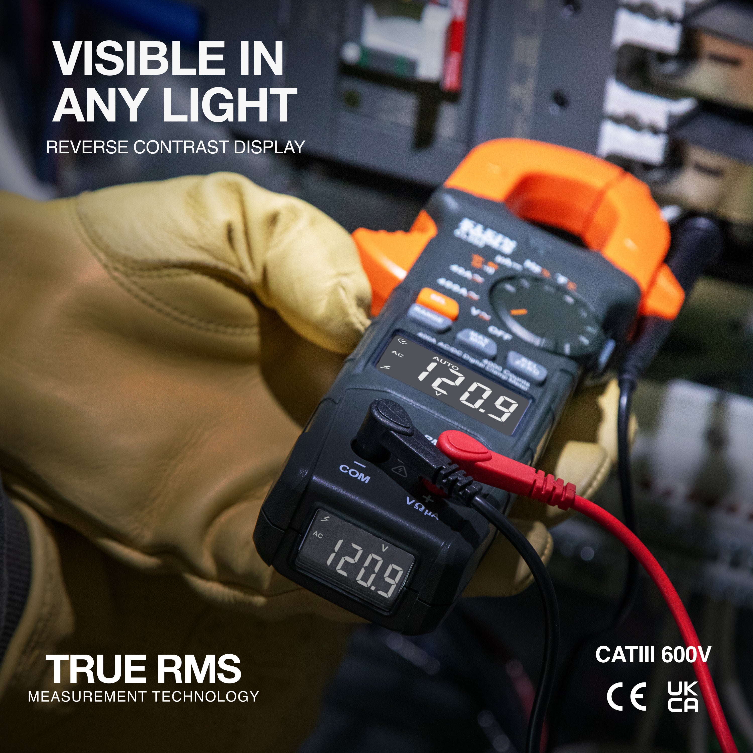 Digital multimeter held by a gloved hand with visible display, brand 'True RMS' mentioned.